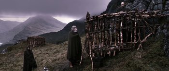 Movie still from “Valhalla Rising” (2009), directed by Nicolas Winding Refn – An old man standing in front of a wooden structure; Wide shot, Low angle
