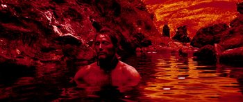 Movie still from “Valhalla Rising” (2009), directed by Nicolas Winding Refn – A man in a body of water near a cliff; Wide shot, High angle