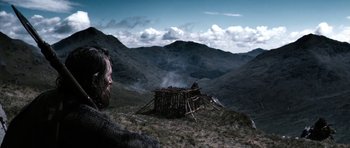 Movie still from “Valhalla Rising” (2009), directed by Nicolas Winding Refn – A man standing on top of a hill next to a hut; Extreme Wide shot, Low angle
