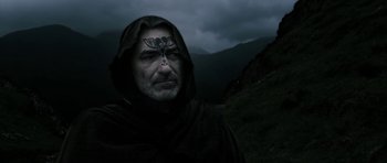 Movie still from “Valhalla Rising” (2009), directed by Nicolas Winding Refn – A man in a hooded cloak with a bird on his forehead; Close Up shot, Low angle