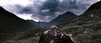 Movie still from “Valhalla Rising” (2009), directed by Nicolas Winding Refn – A person in a field under a cloudy sky; Wide shot, Low angle