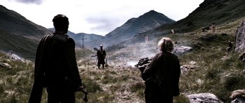 Movie still from “Valhalla Rising” (2009), directed by Nicolas Winding Refn – A group of people standing on top of a grass covered hill; Wide shot, Over the shoulder angle