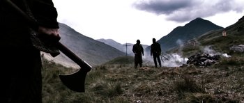 Movie still from “Valhalla Rising” (2009), directed by Nicolas Winding Refn – Two men standing in a field with an axe; Wide shot, Low angle