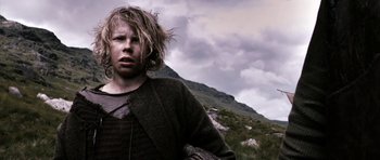 Movie still from “Valhalla Rising” (2009), directed by Nicolas Winding Refn – A young man with long blonde hair wearing a sweater; Medium shot, Low angle