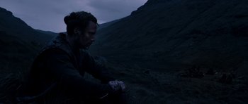 Movie still from “Valhalla Rising” (2009), directed by Nicolas Winding Refn – A man standing on top of a hill looking at his watch; Medium shot, Over the shoulder angle