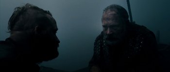 Movie still from “Valhalla Rising” (2009), directed by Nicolas Winding Refn – Two bearded men are talking in a dark room; Close Up shot, Over the shoulder angle