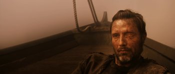 Movie still from “Valhalla Rising” (2009), directed by Nicolas Winding Refn – A person on a boat in the water; Close Up shot, Low angle