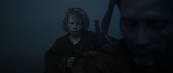 Movie still from “Valhalla Rising” (2009), directed by Nicolas Winding Refn – A young person looking into a mirror in a dark room; Medium shot, Over the shoulder angle
