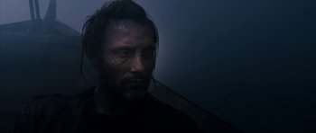 Movie still from “Valhalla Rising” (2009), directed by Nicolas Winding Refn – A person wearing a black t - shirt; Close Up shot, Over the shoulder angle