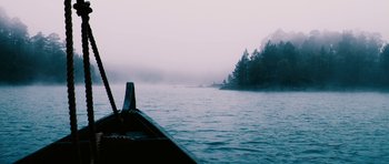 Movie still from “Valhalla Rising” (2009), directed by Nicolas Winding Refn – A boat is traveling on a body of water; Extreme Wide shot, High angle