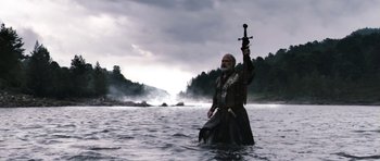 Movie still from “Valhalla Rising” (2009), directed by Nicolas Winding Refn – A man in a river holding a sword; Wide shot, Low angle