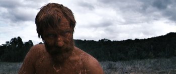 Movie still from “Valhalla Rising” (2009), directed by Nicolas Winding Refn – A person with dirt on his face; Close Up shot, Low angle