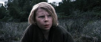 Movie still from “Valhalla Rising” (2009), directed by Nicolas Winding Refn – A young person with blonde hair and a brown jacket; Close Up shot, Low angle