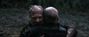 Movie still from “Valhalla Rising” (2009), directed by Nicolas Winding Refn – Two men embracing each other in a wooded area; Close Up shot, High angle