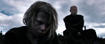 Movie still from “Valhalla Rising” (2009), directed by Nicolas Winding Refn – A man and a woman are standing in a field; Close Up shot, Low angle