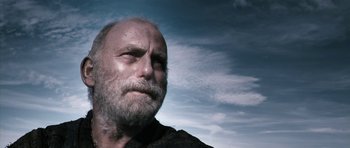 Movie still from “Valhalla Rising” (2009), directed by Nicolas Winding Refn – An old man with a beard is looking into the distance; Close Up shot, Low angle