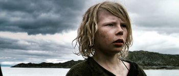 Movie still from “Valhalla Rising” (2009), directed by Nicolas Winding Refn – A young girl with long blonde hair looking into the distance; Close Up shot, Low angle