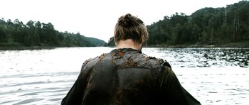 Movie still from “Valhalla Rising” (2009), directed by Nicolas Winding Refn – A person wearing a leather jacket standing in the water; Medium shot, Over the shoulder angle