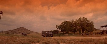 Movie still from “Vampires” (1998), directed by John Carpenter – A truck is parked in the middle of a grassy field; Extreme Wide shot, Low angle