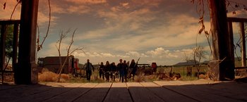 Movie still from “Vampires” (1998), directed by John Carpenter – A group of people sitting on top of a wooden platform; Wide shot, Low angle