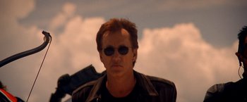 Movie still from “Vampires” (1998), directed by John Carpenter – A person wearing sunglasses and a leather jacket; Close Up shot, Low angle