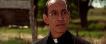 Movie still from “Vampires” (1998), directed by John Carpenter – A man wearing glasses and a priest's outfit; Close Up shot, Low angle
