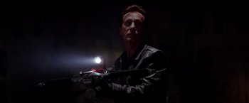 Movie still from “Vampires” (1998), directed by John Carpenter – A man in a leather jacket is holding a gun; Close Up shot, Low angle