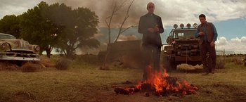 Movie still from “Vampires” (1998), directed by John Carpenter – A man standing in front of a burning fire; Wide shot, Low angle