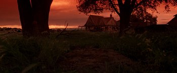 Movie still from “Vampires” (1998), directed by John Carpenter – A house in the middle of a field with a sunset in the background; Extreme Wide shot, Low angle