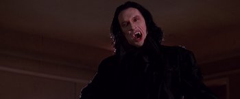 Movie still from “Vampires” (1998), directed by John Carpenter – A man with long black hair and a white face; Close Up shot, Low angle