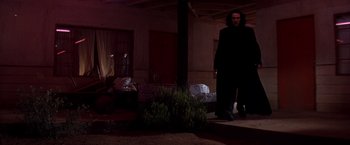 Movie still from “Vampires” (1998), directed by John Carpenter – A man standing on the porch of a house; Wide shot, Low angle