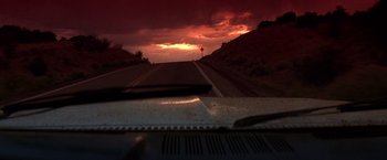 Movie still from “Vampires” (1998), directed by John Carpenter – The sun is setting over a road with a car on it; Extreme Wide shot, Low angle