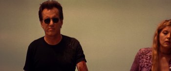 Movie still from “Vampires” (1998), directed by John Carpenter – A man wearing sunglasses and a black shirt; Close Up shot, Low angle