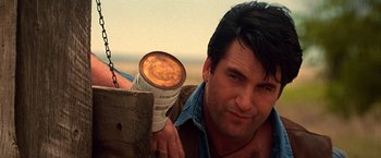 Movie still from “Vampires” (1998), directed by John Carpenter – A person holding a light bulb; Close Up shot, Low angle