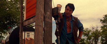 Movie still from “Vampires” (1998), directed by John Carpenter – A man leaning against a wooden pole; Medium shot, Low angle