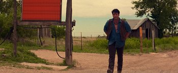 Movie still from “Vampires” (1998), directed by John Carpenter – A man walking down a dirt road next to a pole; Wide shot, Low angle