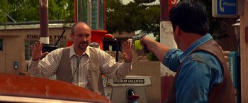 Movie still from “Vampires” (1998), directed by John Carpenter – A man holding a gun up to another man's hand; Medium shot, Over the shoulder angle