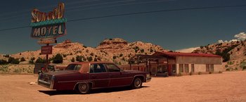 Movie still from “Vampires” (1998), directed by John Carpenter – An old car parked in front of a building in the desert; Extreme Wide shot, Low angle