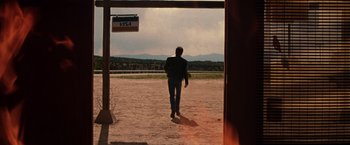 Movie still from “Vampires” (1998), directed by John Carpenter – A man is walking in a dirt field; Wide shot, Low angle