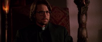 Movie still from “Vampires” (1998), directed by John Carpenter – A man wearing glasses and a priest's outfit; Close Up shot, Low angle