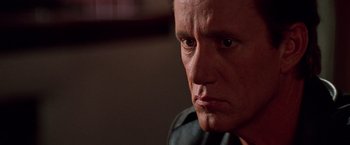 Movie still from “Vampires” (1998), directed by John Carpenter – A man's face in a dark room; Close Up shot, Low angle