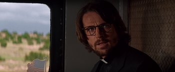 Movie still from “Vampires” (1998), directed by John Carpenter – A man wearing glasses and a priest's outfit; Close Up shot, Low angle