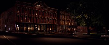 Movie still from “Vampires” (1998), directed by John Carpenter – A night view of a street corner in front of a large building; Extreme Wide shot, High angle