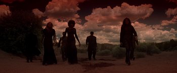 Movie still from “Vampires” (1998), directed by John Carpenter – A group of people standing in the desert under a cloudy sky; Wide shot, Low angle