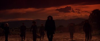 Movie still from “Vampires” (1998), directed by John Carpenter – A group of people walking on a dirt road; Wide shot, Low angle
