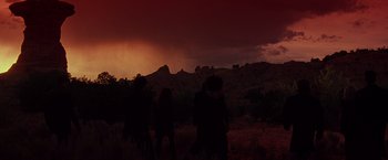 Movie still from “Vampires” (1998), directed by John Carpenter – A group of people standing on top of a grass covered field; Extreme Wide shot, Low angle