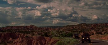Movie still from “Vampires” (1998), directed by John Carpenter – A truck driving down a road through a valley; Extreme Wide shot, Low angle
