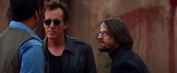 Movie still from “Vampires” (1998), directed by John Carpenter – Two men standing next to each other wearing glasses; Close Up shot, Over the shoulder angle