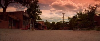 Movie still from “Vampires” (1998), directed by John Carpenter – An empty dirt road with a cloudy sky in the background; Extreme Wide shot, Low angle