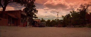 Movie still from “Vampires” (1998), directed by John Carpenter – An empty dirt road with a truck parked in the middle of the road; Extreme Wide shot, Low angle